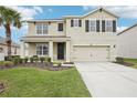 Two-story home featuring a two-car garage, well-kept lawn, and an inviting covered front porch at 3387 Tawny Grove Pl, Lakeland, FL 33811