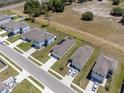 Aerial view showcases houses in a neighborhood featuring well-maintained streets, green spaces, and nearby wooded areas at 726 Eagle Landing Blvd, Winter Haven, FL 33880