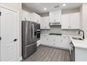 Modern white kitchen featuring stainless steel appliances, tile backsplash, and sleek countertops at 7700 Somersworth Dr, Kissimmee, FL 34747