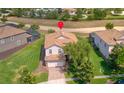 Aerial view of a home with a red pin locator, showcasing its tile roof, two-car garage, and landscaped yard at 1401 Wexford Way, Davenport, FL 33896