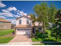 Beautiful two-story home boasts a tile roof, stone accents, a two-car garage, and a well-manicured front lawn at 1401 Wexford Way, Davenport, FL 33896
