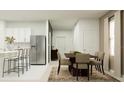 Open-concept dining area with seating for six and stainless steel refrigerator, perfect for entertaining at 3454 Howell Dr, Lake Wales, FL 33859