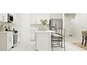 Bright kitchen featuring stainless steel appliances, white cabinets, an island, and adjacent dining area at 3454 Howell Dr, Lake Wales, FL 33859
