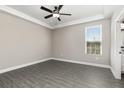 Serene bedroom features a large window, ceiling fan, and a neutral color palette for a relaxing atmosphere at 7704 Somersworth Dr, Kissimmee, FL 34747