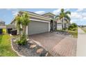 Home features a brick driveway with a landscaped yard, a two-car garage, and a well-maintained exterior at 140 Trinity Ridge Cir, Davenport, FL 33897