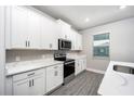 Bright kitchen featuring white cabinets, quartz countertops, and stainless steel appliances at 3319 Chinotto Dr, Lake Alfred, FL 33850