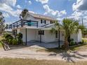 Rear view of the home with an elevated deck, a covered patio, and lush landscaping at 4145 Willis Rd, Mulberry, FL 33860