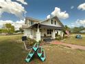 Inviting home featuring a cozy front porch with seating area and well-maintained landscaping at 4145 Willis Rd, Mulberry, FL 33860