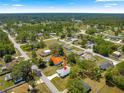 Aerial view of a home in a lush residential area surrounded by mature trees on a sunny day at 12164 Se 85Th Ct, Belleview, FL 34420