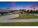 Serene twilight view of a home with a well-kept lawn, spacious driveway, and picturesque neighborhood at 5419 Knights Landing Dr, Lakeland, FL 33810