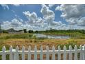 This backyard features a picturesque lake view and white picket fence at 634 Canna Dr, Davenport, FL 33897
