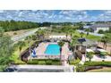 Community pool featuring lounge chairs, sun umbrellas, and lush, tropical landscaping at 634 Canna Dr, Davenport, FL 33897