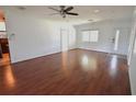 Bright living room with hardwood floors, a ceiling fan, a bright window, and a white front door at 3632 Mockingbird Ln, Orlando, FL 32803