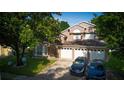 Traditional two-story home featuring a three car garage, manicured lawn, and attractive landscaping at 1315 Olympia Park Cir, Ocoee, FL 34761