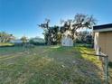 Spacious, fenced backyard featuring a storage shed and lush greenery, perfect for outdoor enjoyment at 2341 Weber St, Lakeland, FL 33801