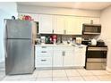 Functional kitchen with stainless steel appliances, white cabinetry, and mosaic backsplash for a modern touch at 2341 Weber St, Lakeland, FL 33801