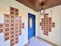 Inviting entryway with a stylish blue door and unique tiled wall accents at 1968 Pleasant Hill Rd, Kissimmee, FL 34746