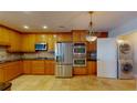 Well-equipped kitchen featuring stainless steel appliances, light-wood cabinets and tiled flooring at 2305 Edgewater Dr # 1606, Orlando, FL 32804
