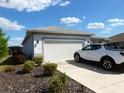 View of the exterior with a paved driveway, garage and a car parked in the driveway at 8890 Sw 104Th Cir, Ocala, FL 34481