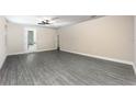 Bright living room with wood-look floors and a glass door leading to the backyard at 7672 Somersworth Dr, Kissimmee, FL 34747
