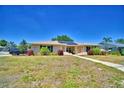 Inviting single-story home with a manicured front lawn, beautiful landscaping, and solar panels for energy efficiency at 53 Paine Dr, Winter Haven, FL 33884
