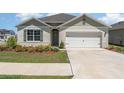 Charming single-Gathering home featuring a two-car garage and inviting front yard with colorful landscaping at 947 Serchio St, Haines City, FL 33844