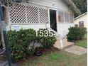 The house has a unique lattice design with a visible address and well-kept bushes at 1529 Indiana St, Orlando, FL 32805
