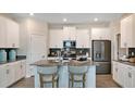 Modern kitchen with stainless steel appliances, kitchen island with chairs, and subway tile backsplash at 4662 Coral Harbour Rd, Kissimmee, FL 34758