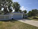 Attached two-car garage with a concrete driveway and well-maintained lawn at 3446 Country Manor Dr, Port Orange, FL 32129
