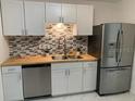 Updated kitchen boasts stainless steel appliances, tile backsplash, and sleek countertops at 3601 Ne 24Th Ct, Ocala, FL 34479