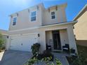 Inviting home featuring a quaint porch with seating and a two-car garage at 1204 Berry Ln, Davenport, FL 33837