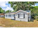 View of the well-maintained one-story home exterior with green lawns, landscaping and mature trees at 1480 E Davidson St, Bartow, FL 33830
