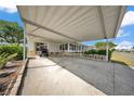 Carport of home showing golf cart, manicured bushes, covered entry, and access to Florida room at 1610 Reynolds Rd # 353, Lakeland, FL 33801