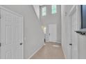 Bright hallway featuring neutral paint, tile floors, and a staircase leading to the upper level at 1859 Carnostie Rd, Winter Haven, FL 33884