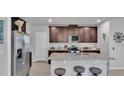 Modern kitchen featuring granite countertops, stainless steel appliances, and dark wood cabinets at 1859 Carnostie Rd, Winter Haven, FL 33884