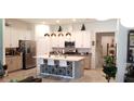 Bright kitchen with modern white cabinets, island with seating, and stainless steel appliances at 753 Grand Hilltop Dr, Apopka, FL 32703