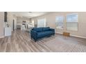 Open-concept living room with modern furniture, wood-look flooring, and an easy flow to the kitchen and dining area at 1646 Seth Dr, Winter Haven, FL 33880