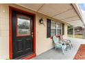 Close-up of the front door and sitting area on the covered porch of the home at 222 Aldo Dr, Babson Park, FL 33827