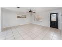 Bright living room featuring tile floors, ceiling fan, and natural light from large windows at 222 Aldo Dr, Babson Park, FL 33827