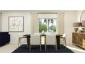 Sunlit dining room with modern table and chairs, artwork, and large window at 1397 Acorn Meadow Loop, Eustis, FL 32726