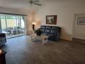 Comfortable living room with wood flooring and a sliding glass door to the lanai at 6030 Dijulio Ter, The Villages, FL 32163