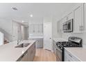 Modern kitchen with gray cabinets, stainless steel appliances, gas range and a large island with a sink at 1620 Ellesmere Ave, Haines City, FL 33844