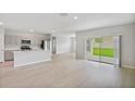Bright and airy living room with open floor plan, light wood floors, and sliding glass doors to the backyard at 1620 Ellesmere Ave, Haines City, FL 33844