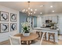 Open-concept dining area featuring modern chandelier and adjacent kitchen at 3823 King Hill Dr, Haines City, FL 33844