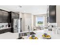 Modern kitchen featuring stainless steel appliances, white quartz countertops, and a breakfast nook with natural light at 5131 Bridgehaven Rd, Davenport, FL 33837