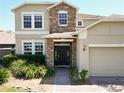 Beautiful home featuring a stone entryway, a well-manicured lawn, and lots of natural light at 1705 Plantation Pointe Dr, Orlando, FL 32824
