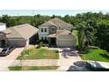 Charming two-story home boasting a stone facade, attached garage, brick driveway, and manicured lawn at 1705 Plantation Pointe Dr, Orlando, FL 32824