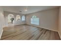 Bright living room featuring laminate flooring and archways to the kitchen at 105 Evergreen Dr, Auburndale, FL 33823