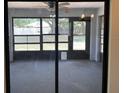 View of the carpeted lanai with screened windows and view of the fenced backyard at 11757 Se 71St Terrace Rd, Belleview, FL 34420