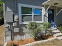 Close-up of the home's exterior, featuring a blue front door, window, and neat landscaping at 1960 Hamilton St, Bartow, FL 33830